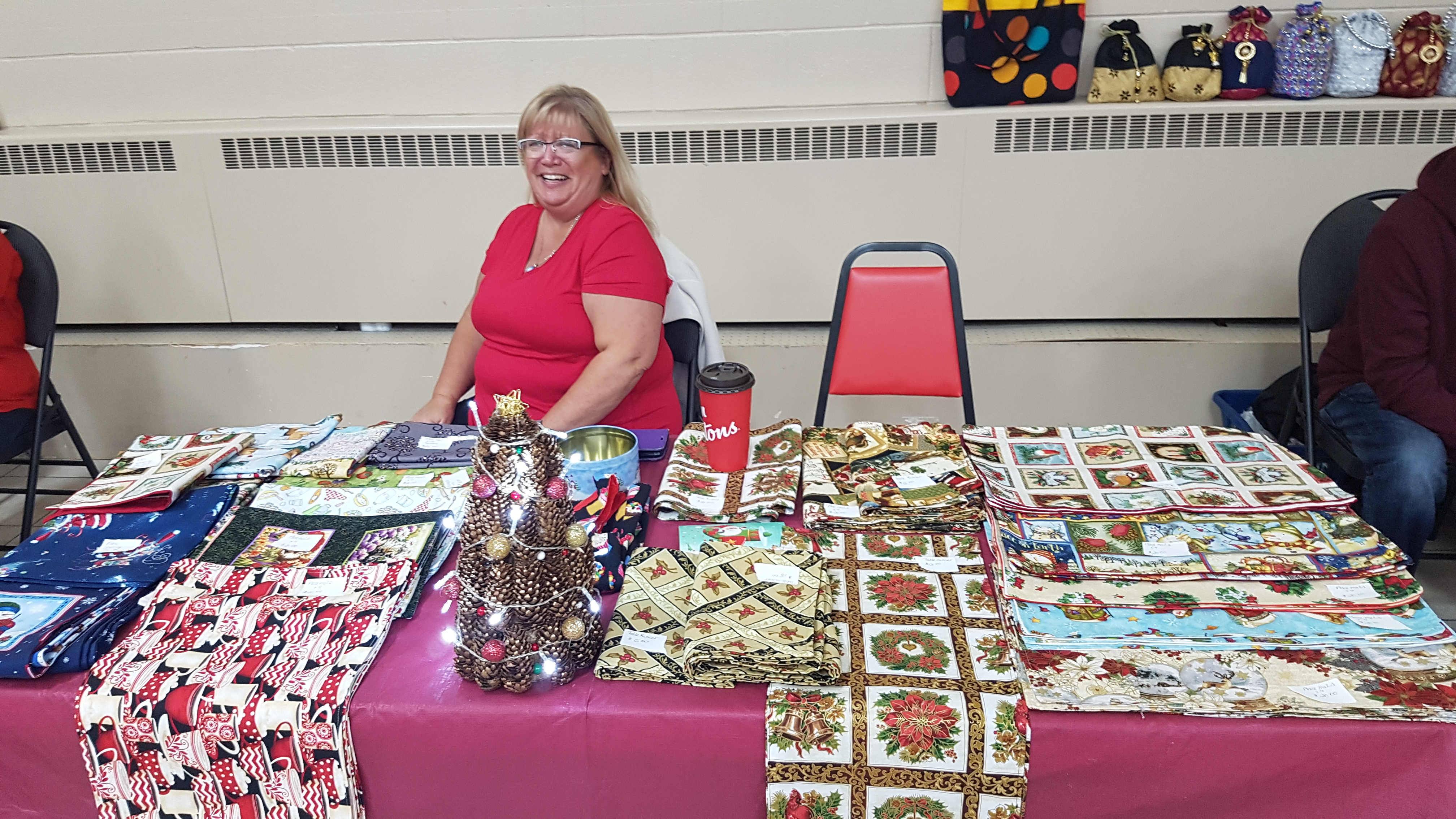 picture of vendor at her table selling christmas table runners