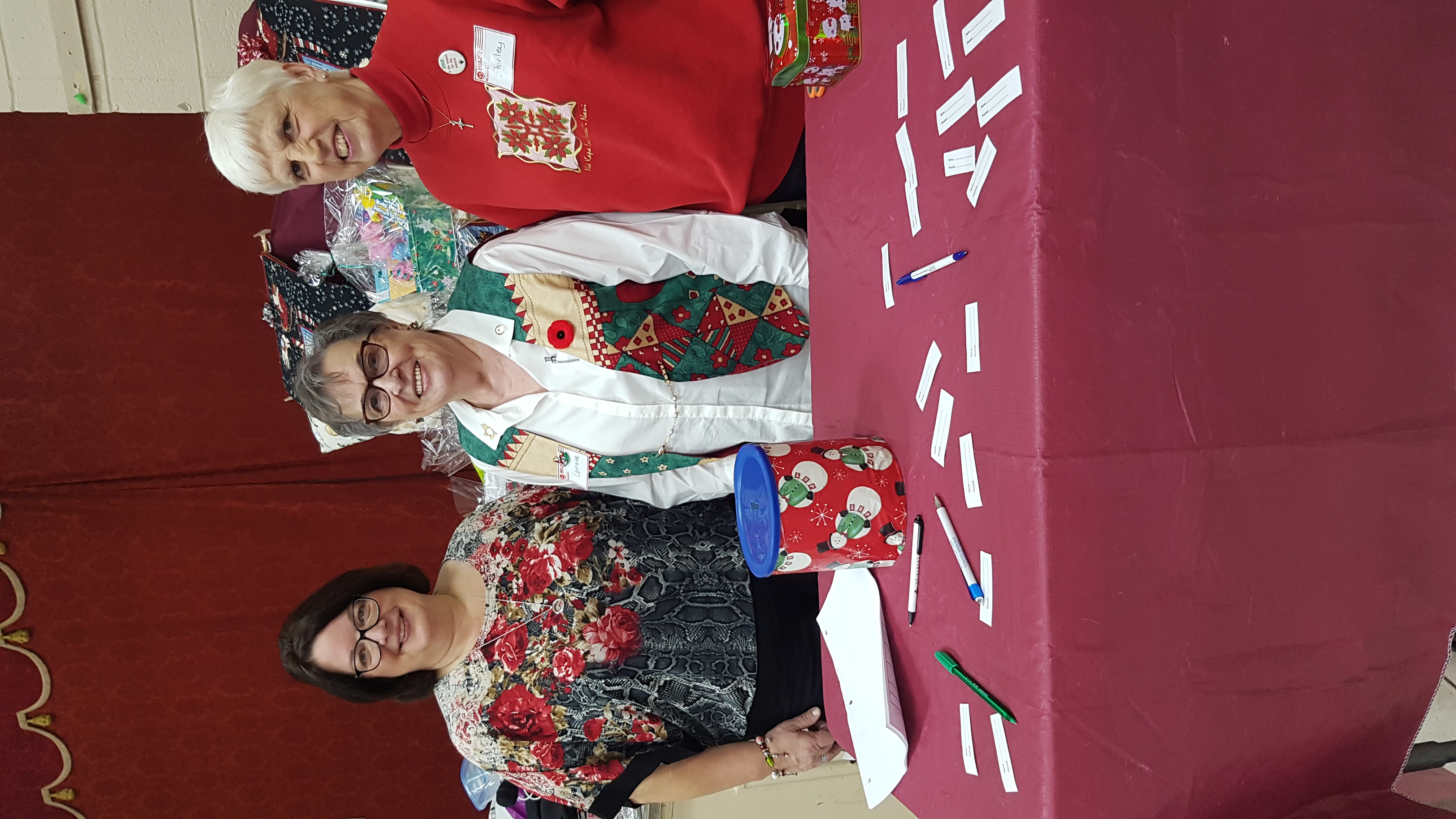 picture of Mirella, Lorraine and Shirley behind the raffle tickets table