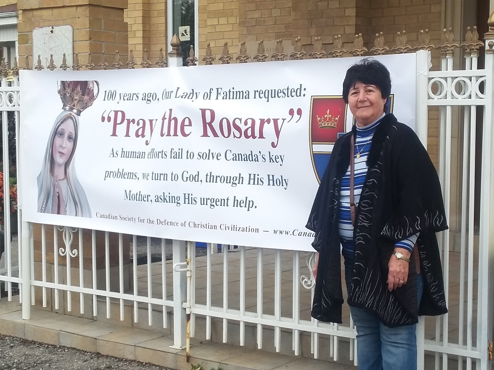 Helen beside the rosary rally banner